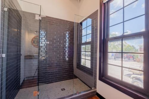 a bathroom with a glass shower with a window at Caribbean Vacation Rentals and The PoolClub at Mahogany! in San Pedro