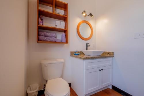a bathroom with a toilet and a sink at Caribbean Vacation Rentals and The PoolClub at Mahogany! in San Pedro