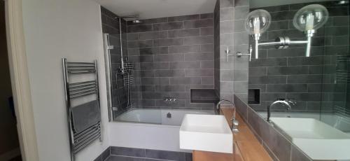 uma casa de banho com um lavatório e uma banheira em Rare luxury Harbourview apartment sleeps 6 em Torquay