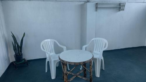 3 sillas blancas y una mesa en una habitación en Monoambiente céntrico en Concordia