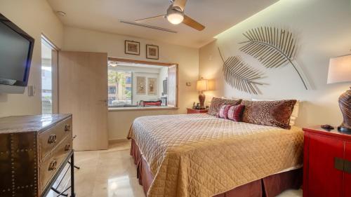 1 dormitorio con 1 cama y TV de pantalla plana en One Medano 8B, en Cabo San Lucas