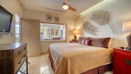 a bedroom with a bed and a flat screen tv at One Medano 8B in Cabo San Lucas