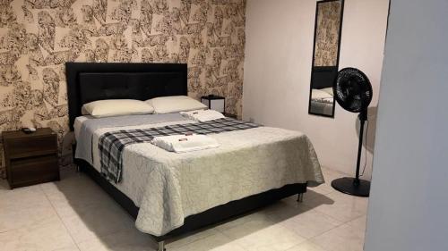 een slaapkamer met een bed met een zwart-witte deken bij Tiger Hostel in Medellín