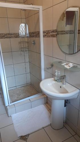 a bathroom with a sink and a shower at Umqhele Guest Lodge in Richards Bay