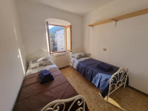 a bedroom with two beds and a window at Il Borgo Apartment in Pignone