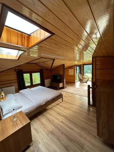 een slaapkamer met een groot bed in een kamer met houten wanden bij Özen Villa Apart in Uzungol