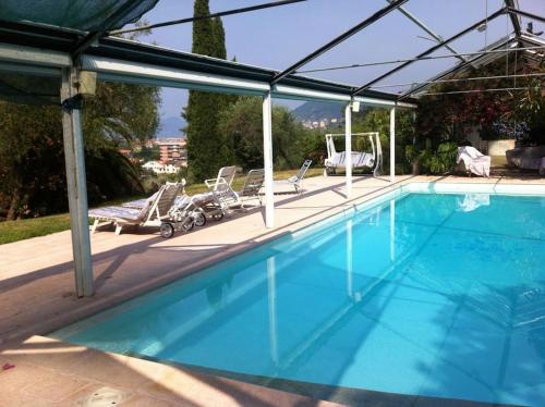 uma grande piscina com cadeiras em [Portofino] Appartamento in Villa vista mare em Lavagna