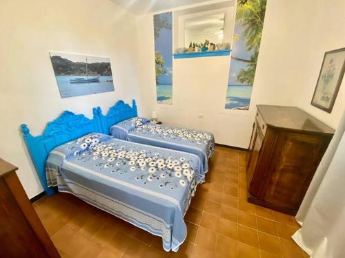 duas camas num quarto com pinturas na parede em [Portofino] Appartamento in Villa vista mare em Lavagna