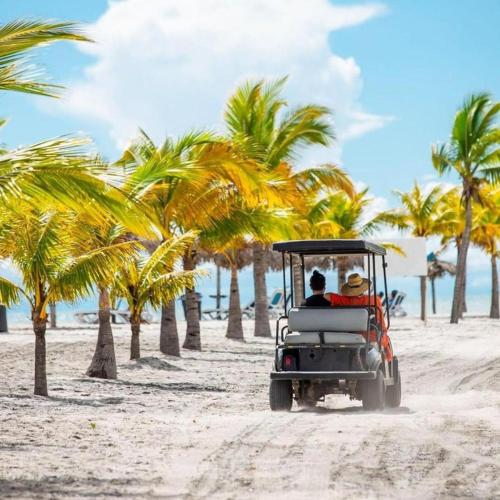 two people riding in a golf cart on the beach at Playa Blanca Panama in Río Hato