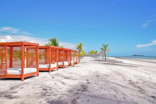 a row of orange shelters on a beach at Playa Blanca Panama in Río Hato
