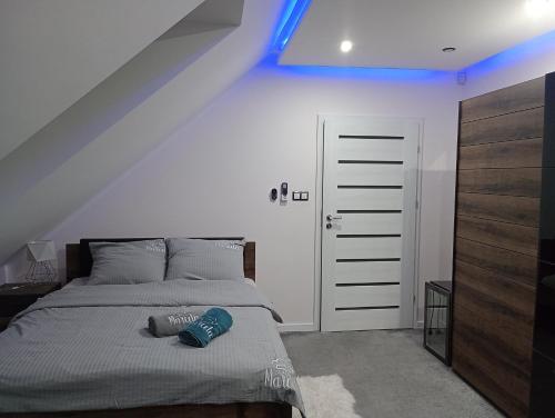 una camera da letto con un letto con una luce blu sopra di Motelik Zajazd u Marcela a Bysław
