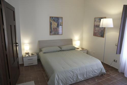 1 dormitorio con 1 cama con 2 mesitas de noche y 2 lámparas en Casa delle Macine, en Caltanissetta