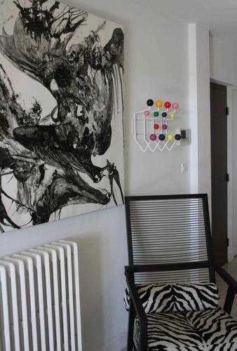 a room with a chair and a painting on the wall at Superbe T4 à Royan, 2 minutes à pied de la mer. in Royan