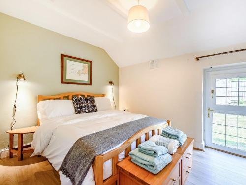 a bedroom with a bed with towels on a table at Studio Cottage in Treffynnon 