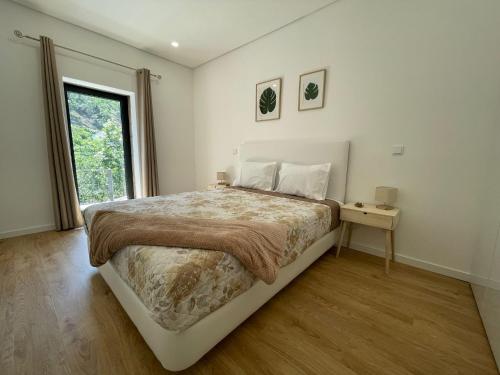 a bedroom with a large bed and a window at Teixeira Home - Gerês in Geres