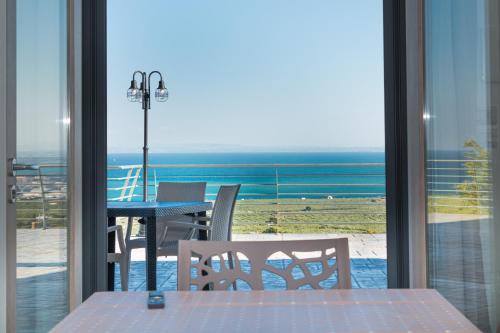 a balcony with a table and chairs and a view of the ocean at Villa Terrazza sul Golfo in Monte SantʼAngelo