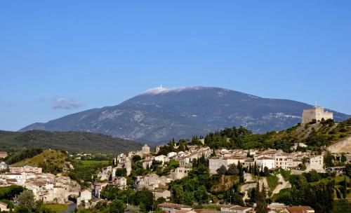 uma cidade numa colina com uma montanha ao fundo em Annapurna Bed & Breakfast em Vaison-la-Romaine