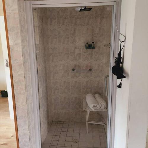 a shower with a glass door in a bathroom at Mercy's Getaway Place in Cape Town