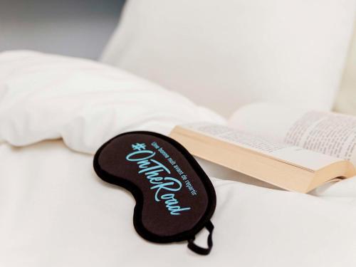 a black and white guitar keychain on a bed at hotelF1 Paris Porte de Châtillon in Paris