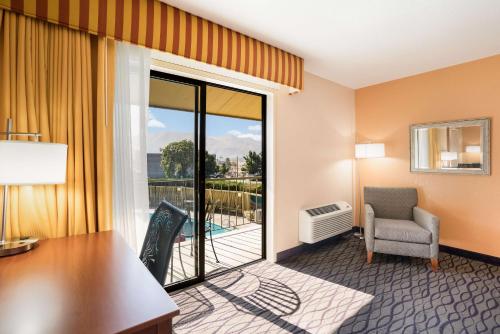 a hotel room with a desk and chair and a balcony at SureStay Hotel by Best Western Wenatchee in Wenatchee