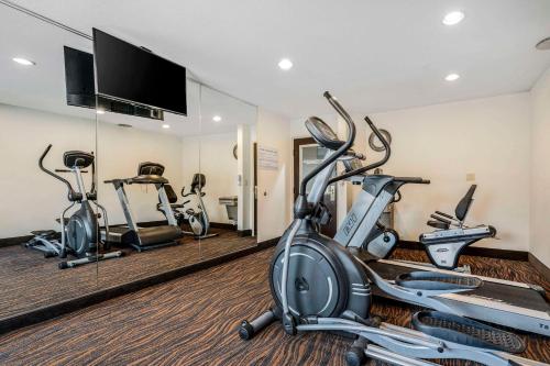 a gym with three exercise bikes in a room at Sleep Inn in Naperville