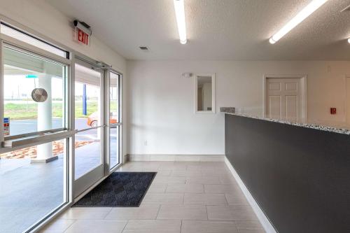 an empty room with a lobby with a counter and glass doors at Suburban Studios Spartanburg - I-26 in Spartanburg