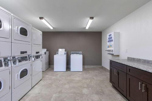 a large kitchen with white appliances in a room at Suburban Studios Spartanburg - I-26 in Spartanburg