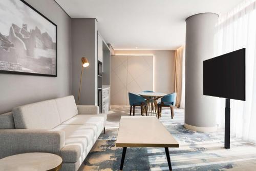 a living room with a couch and a tv at Radisson Blu Hotel Riyadh Convention and Exhibition Center in Riyadh
