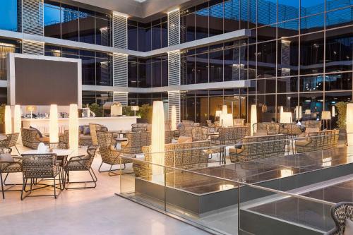 a lobby with chairs and tables in a building at Radisson Blu Hotel Riyadh Convention and Exhibition Center in Riyadh