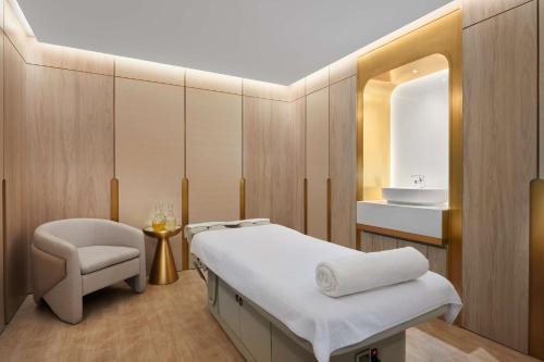 a room with a bed and a chair and a mirror at Radisson Blu Hotel Riyadh Convention and Exhibition Center in Riyadh
