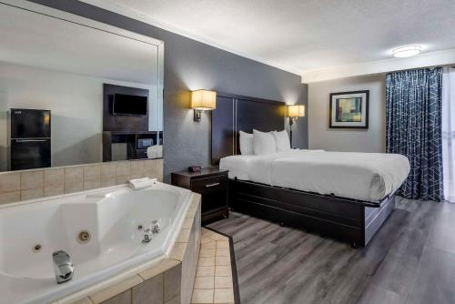 a hotel room with a bed and a bath tub at Suburban Studios in Rock Hill