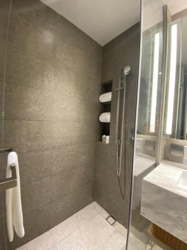 een badkamer met een glazen douche en een wastafel bij Ruby’s in Bao'an