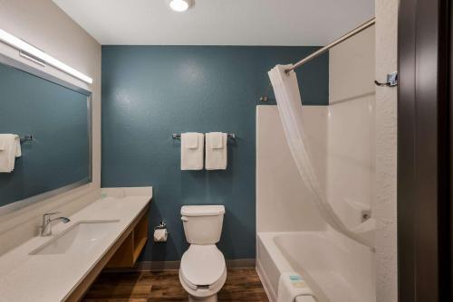a bathroom with a toilet and a sink and a shower at WoodSpring Suites West Palm Beach in West Palm Beach