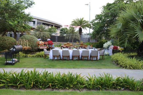a table with white tables and chairs in a park at Wyndham Grand KN Paradise Cam Ranh in Cam Ranh