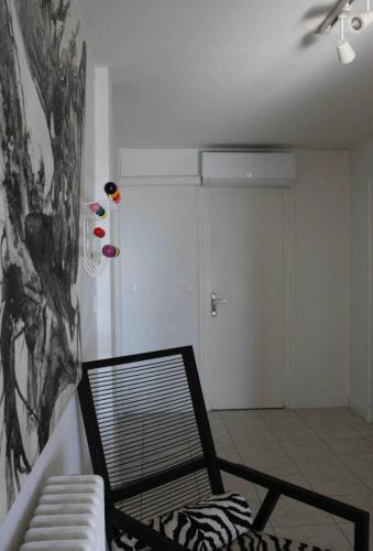 a living room with a chair and a door at Superbe T4 à Royan, 2 minutes à pied de la mer. in Royan