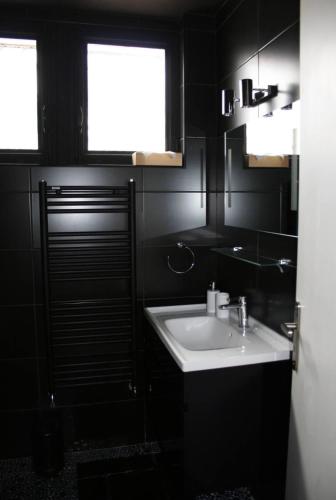 a black bathroom with a sink and a window at Superbe T4 à Royan, 2 minutes à pied de la mer. in Royan
