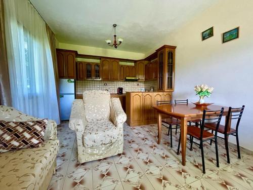 a living room with a table and chairs and a kitchen at Cortina House Berat in Kuçovë