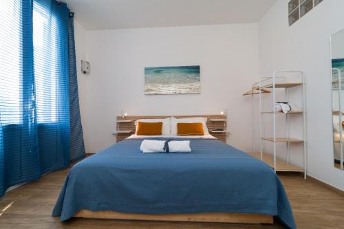 een slaapkamer met een blauw bed met 2 oranje kussens bij Lovely Palermo in Palermo