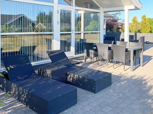 een patio met stoelen en een tafel en stoelen bij 7 person holiday home in Hadsund in Hadsund