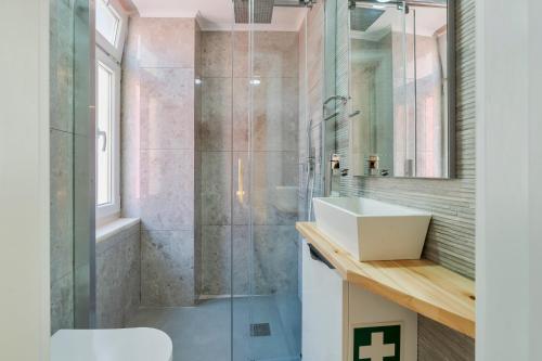 a bathroom with a glass shower and a sink at Bonneville Setúbal II in Setúbal
