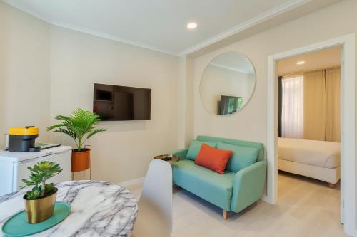 a living room with a blue chair and a mirror at Bonneville Setúbal II in Setúbal