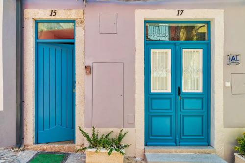 two blue doors on a pink house at Bonneville Setúbal II in Setúbal