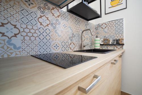 a kitchen with a sink and a tile wall at Lovely Palermo in Palermo