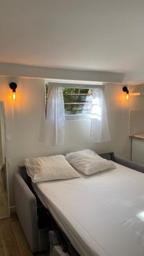 - une chambre avec un grand lit et une fenêtre dans l'établissement Studio proche de Paris et des transports, à Villemomble