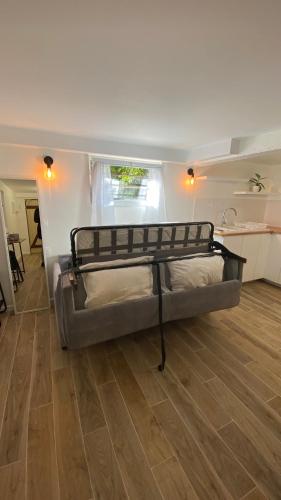 Bett in einem Zimmer mit Holzboden in der Unterkunft Studio proche de Paris et des transports in Villemomble