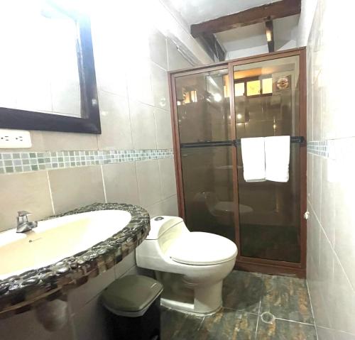 e bagno con servizi igienici, lavandino e doccia. di Exedra de Galeria Cafe. Mindo- Ecuador a Mindo