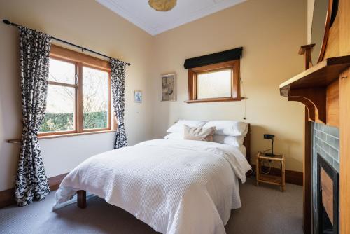 a bedroom with a bed and a window at Cottage on Aotea in Dunedin