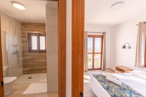 a bathroom with a shower and a bed in a room at Apartamento Chic in Frigiliana