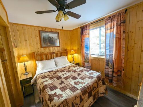 Schlafzimmer mit einem Bett und einem Deckenventilator in der Unterkunft Yellowstone's Treasure Cabins in Gardiner