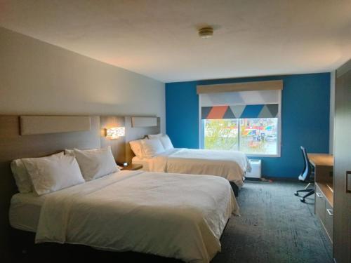 a hotel room with two beds and a window at Holiday Inn Express Lapeer, an IHG Hotel in Lapeer